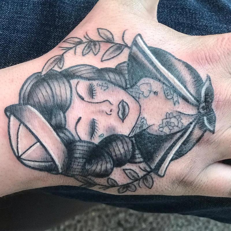 black and grey illustrative woman portrait tattoo on hand