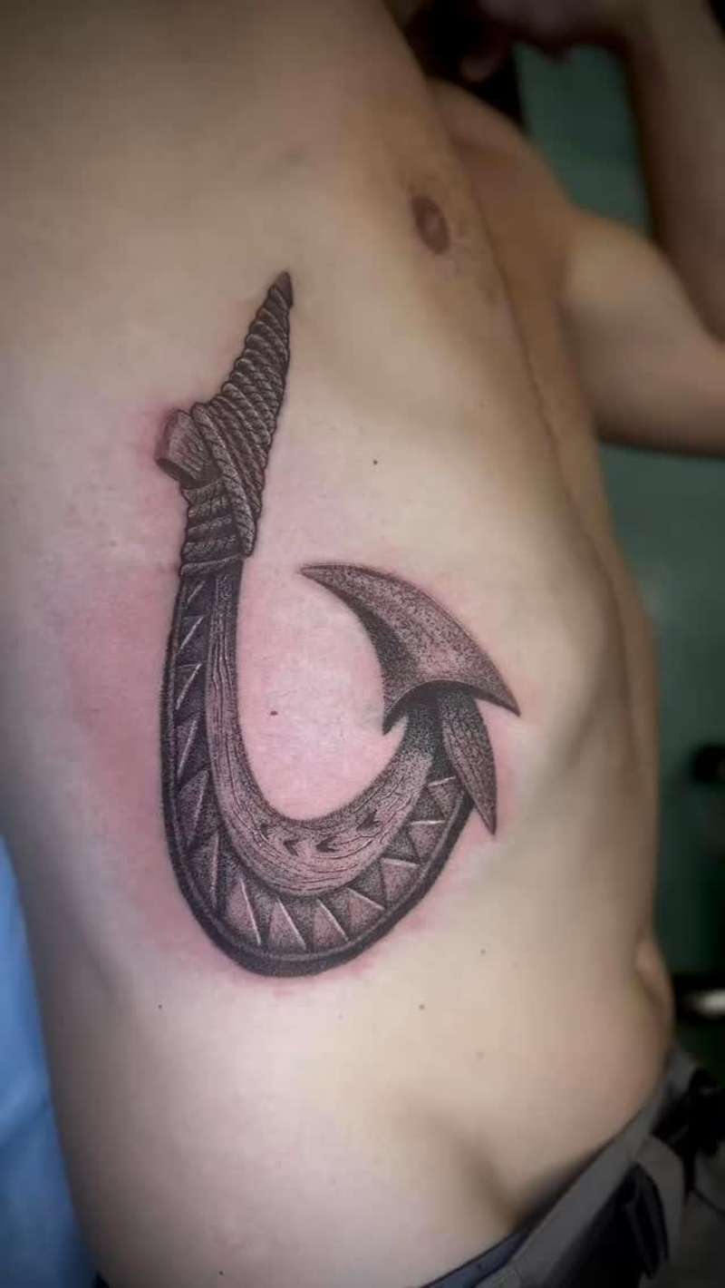 tribal fish hook tattoo on torso with dotwork shading