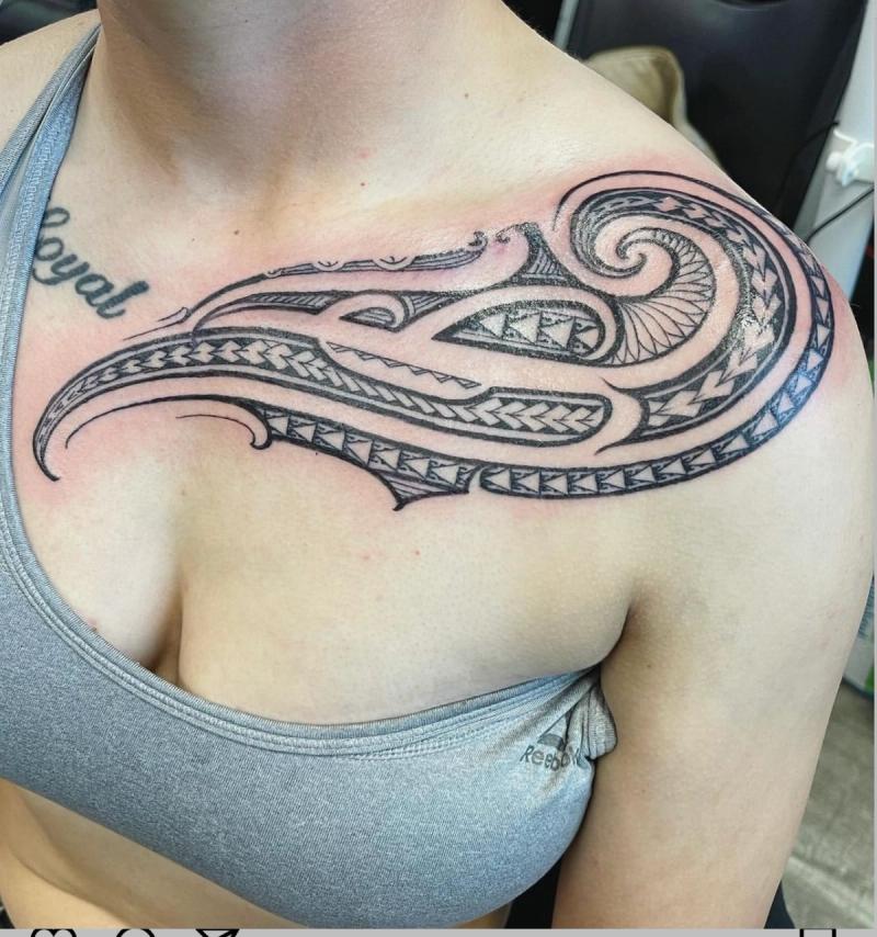 Blackwork tribal design tattoo on chest and shoulder