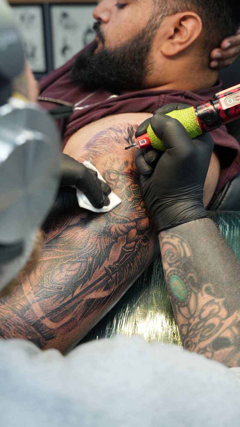 Black and grey intricate design tattoo on upper arm