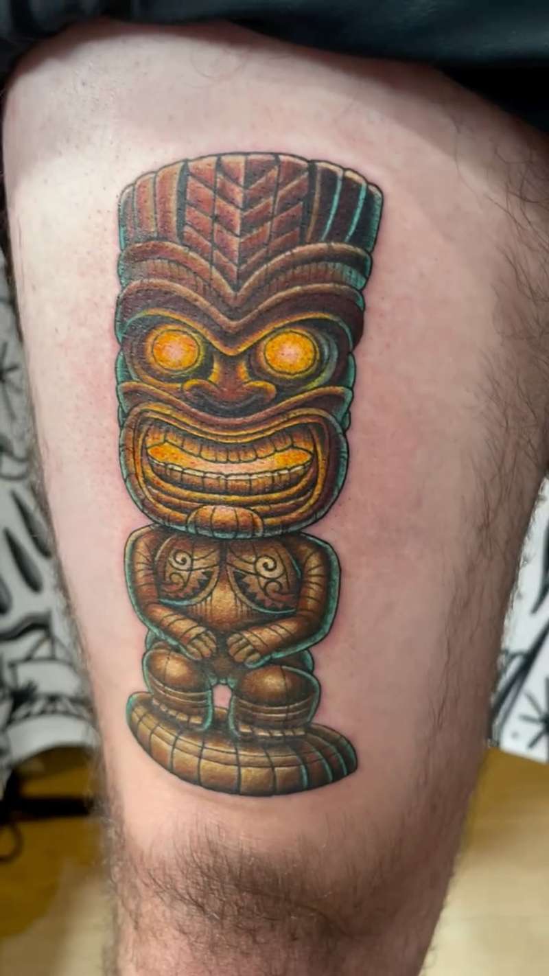 tribal figurine tattoo on thigh