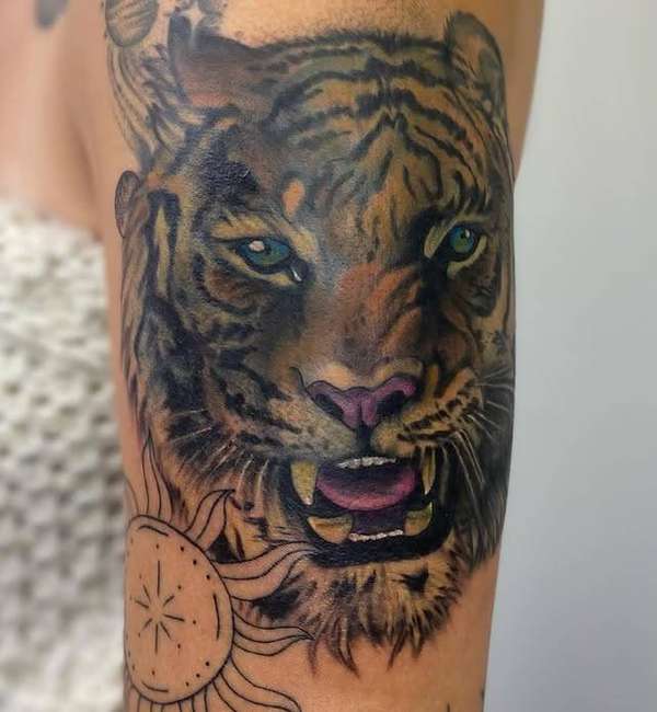 realistic tiger head tattoo in color on upper arm