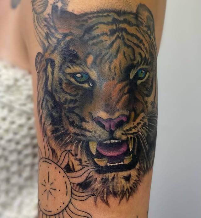 realistic tiger head tattoo in color on upper arm