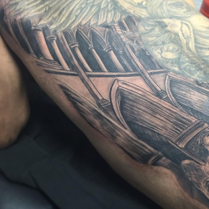 Black and grey realistic architectural tattoo on upper arm.