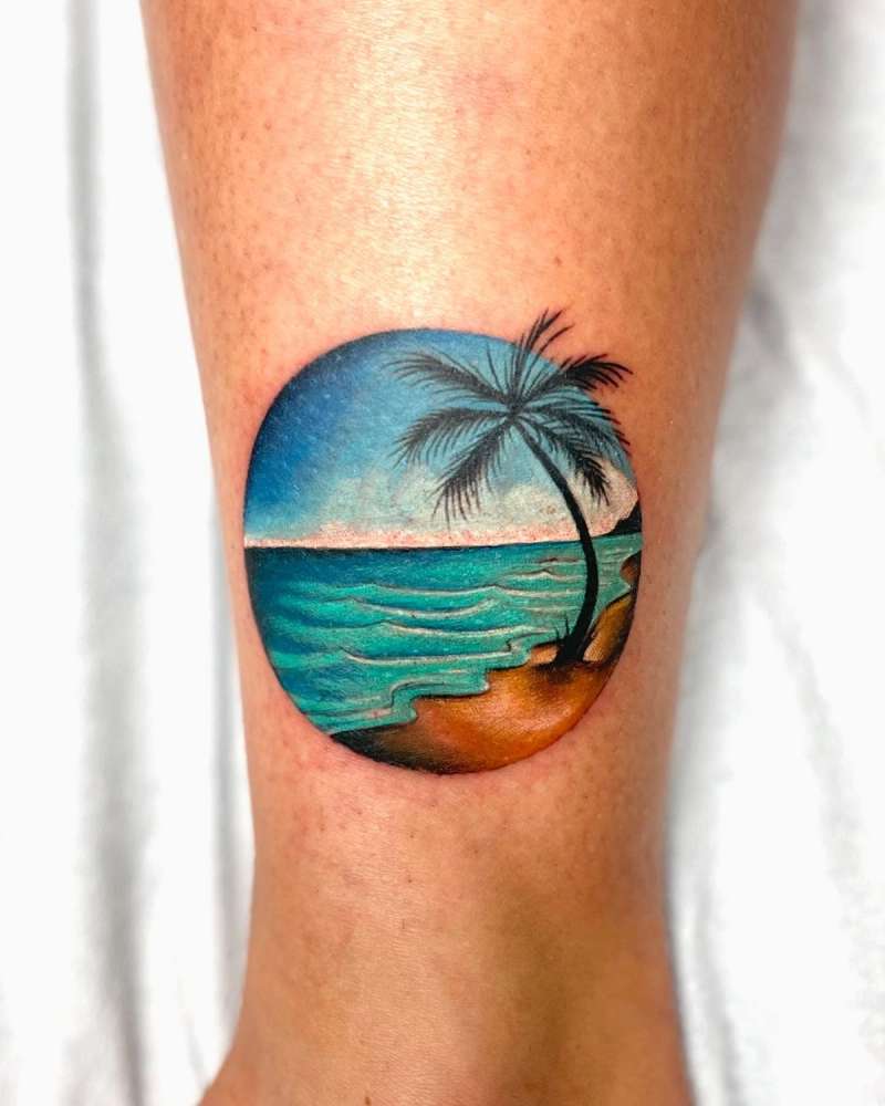 realistic small beach scene tattoo with palm tree on calf