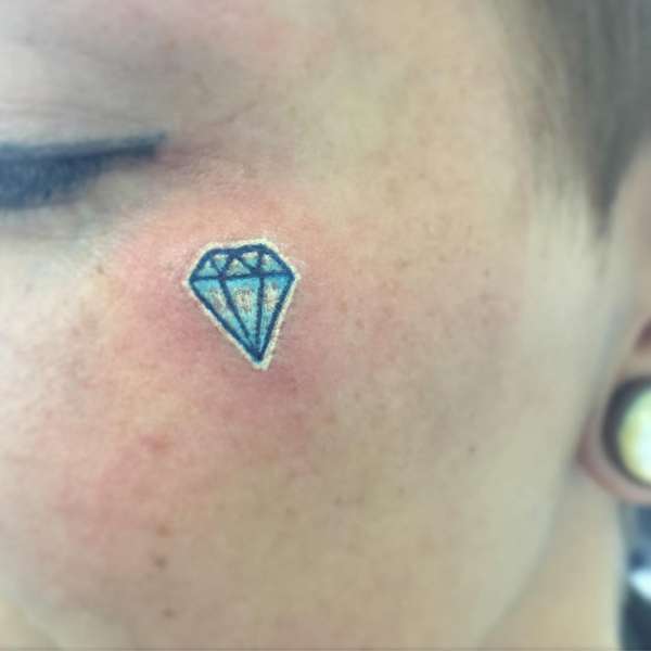 small geometric diamond tattoo on face