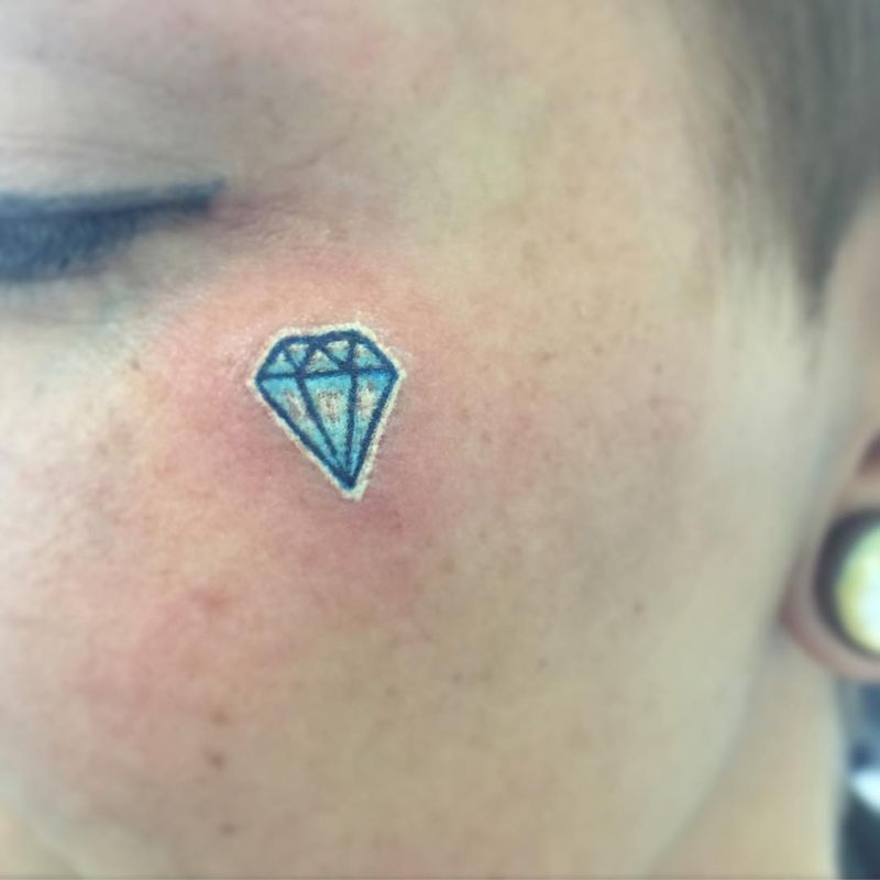 small geometric diamond tattoo on face