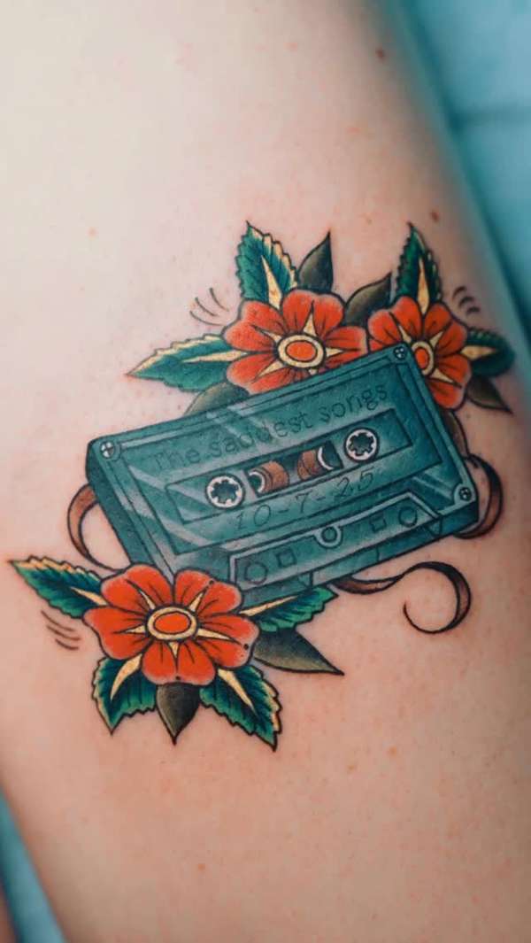 traditional style tattoo of a cassette tape and flowers on an arm
