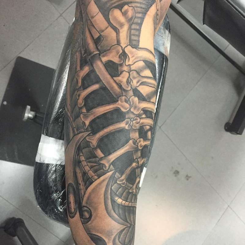 Black and grey biomechanical skeleton tattoo on forearm