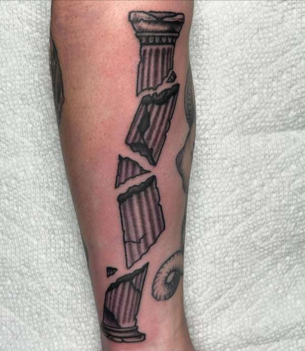 Black and grey illustrative broken column tattoo on forearm.