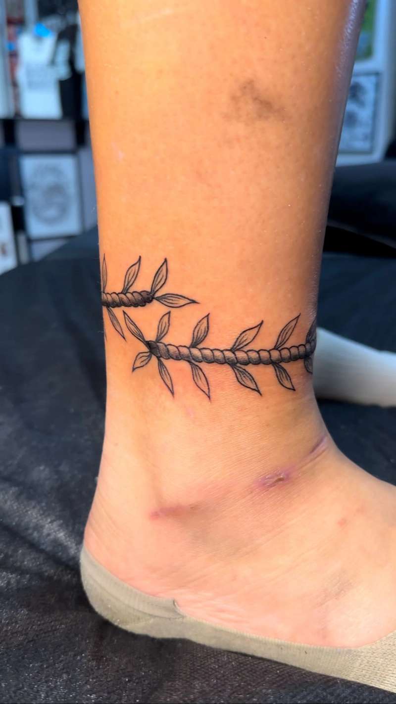 ankle tattoo with black leaves