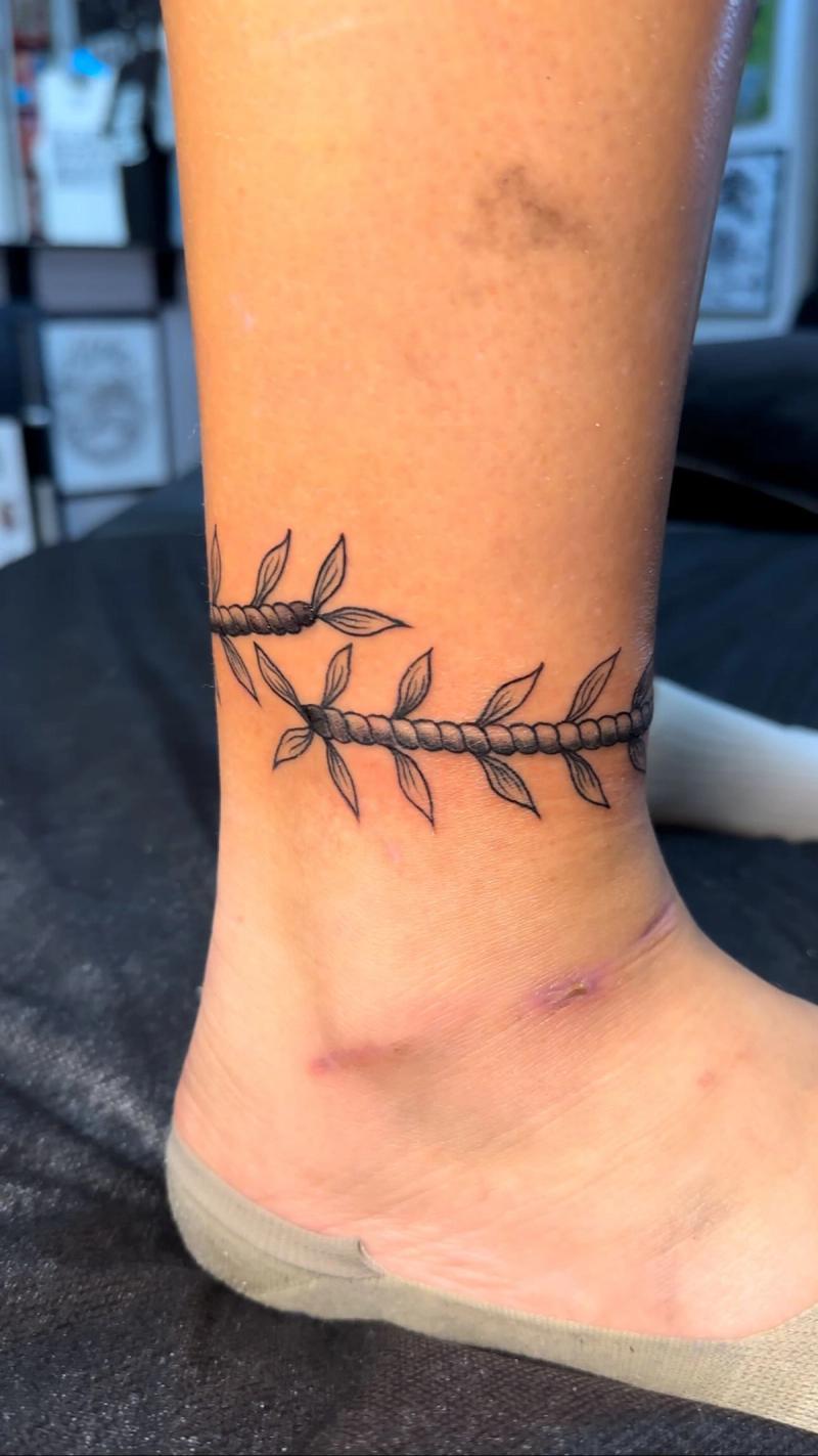 ankle tattoo with black leaves