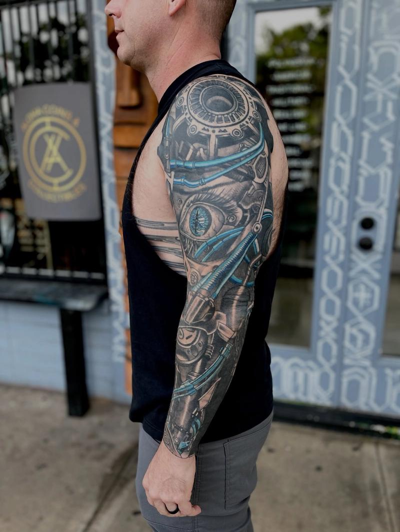 biomechanical full sleeve tattoo with gears and blue mechanical tubes