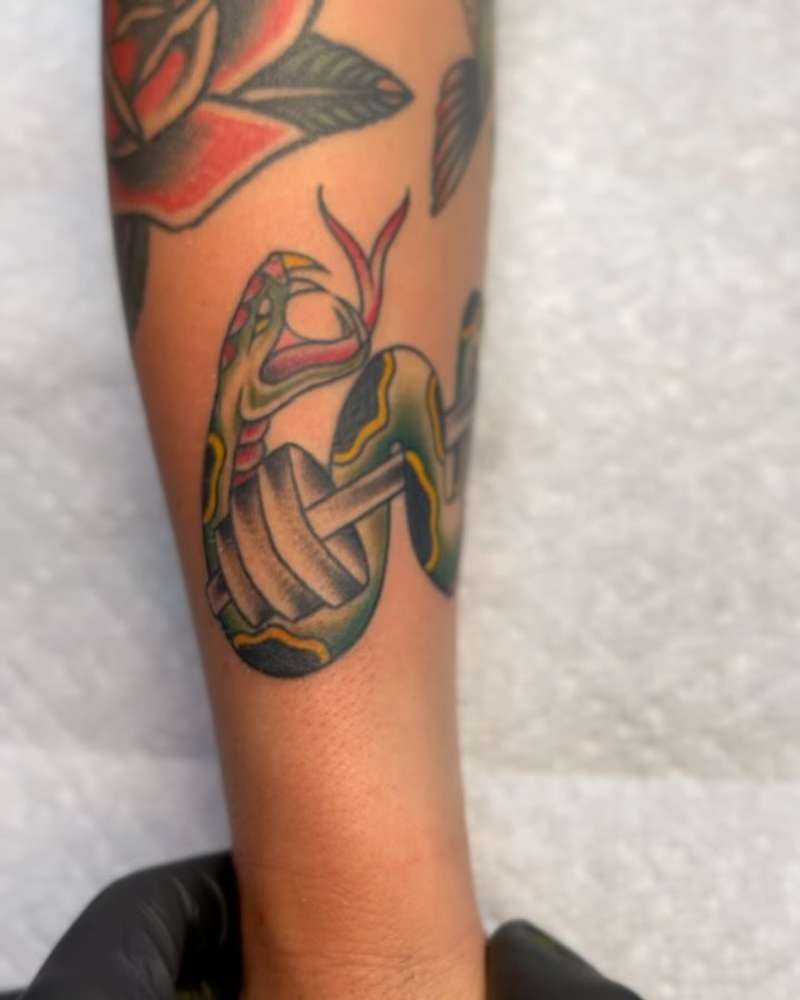 Colorful traditional snake and rose tattoo on forearm