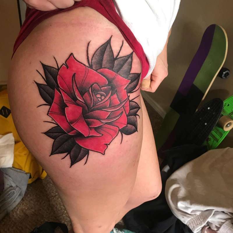 large red rose tattoo on thigh