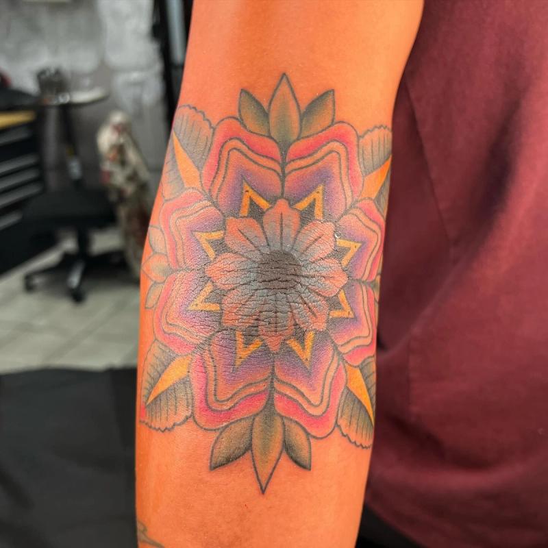 Colorful geometric floral tattoo on forearm