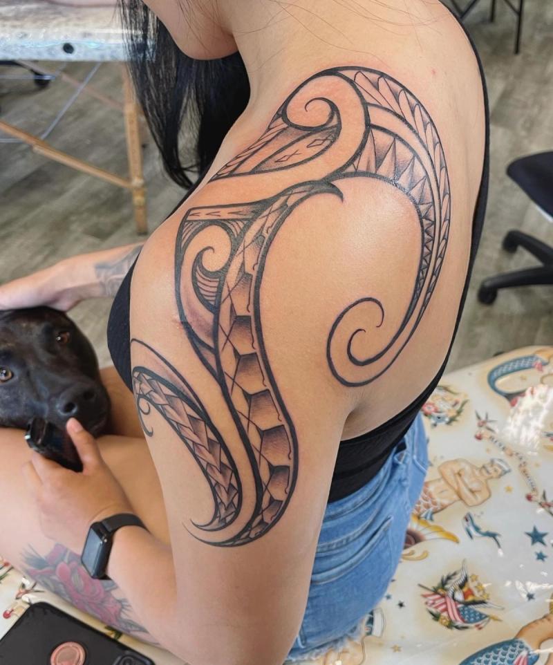 Black and grey tribal tattoo on shoulder with abstract and geometric patterns