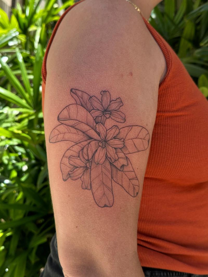 Black and grey botanical flower tattoo on upper arm