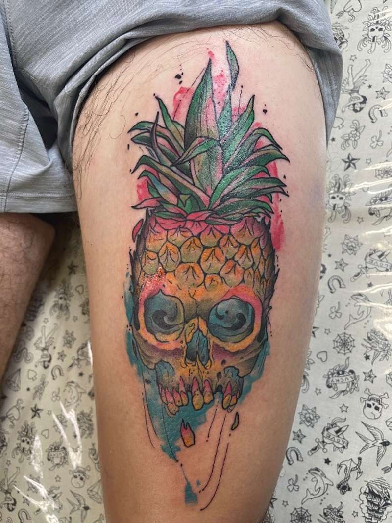 Colorful illustrative pineapple skull tattoo on thigh