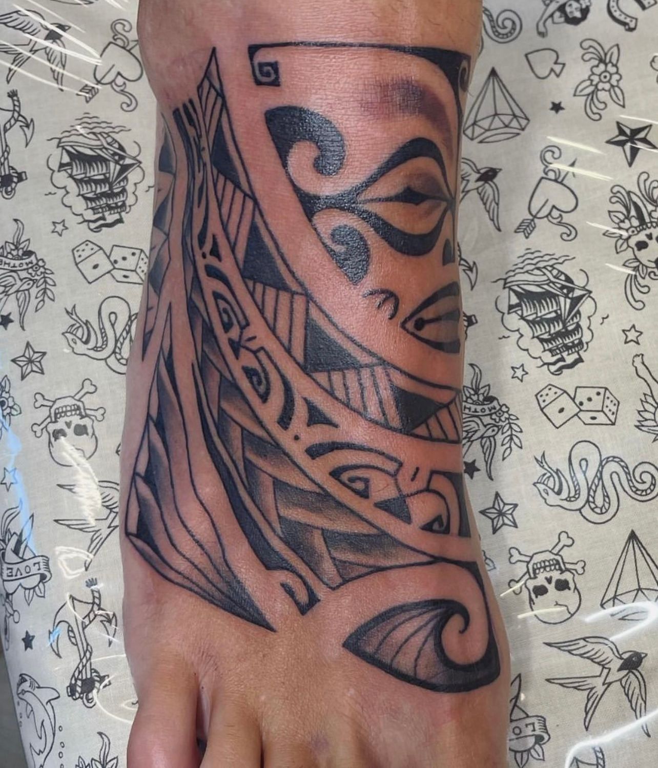 Black tribal pattern tattoo on foot