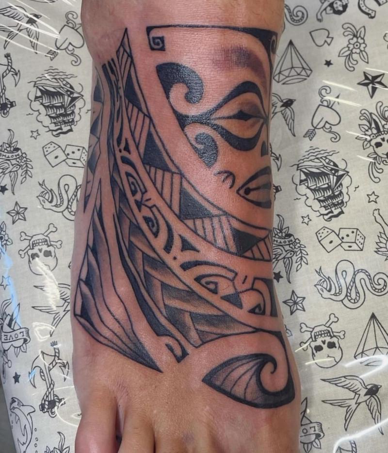 Black tribal pattern tattoo on foot