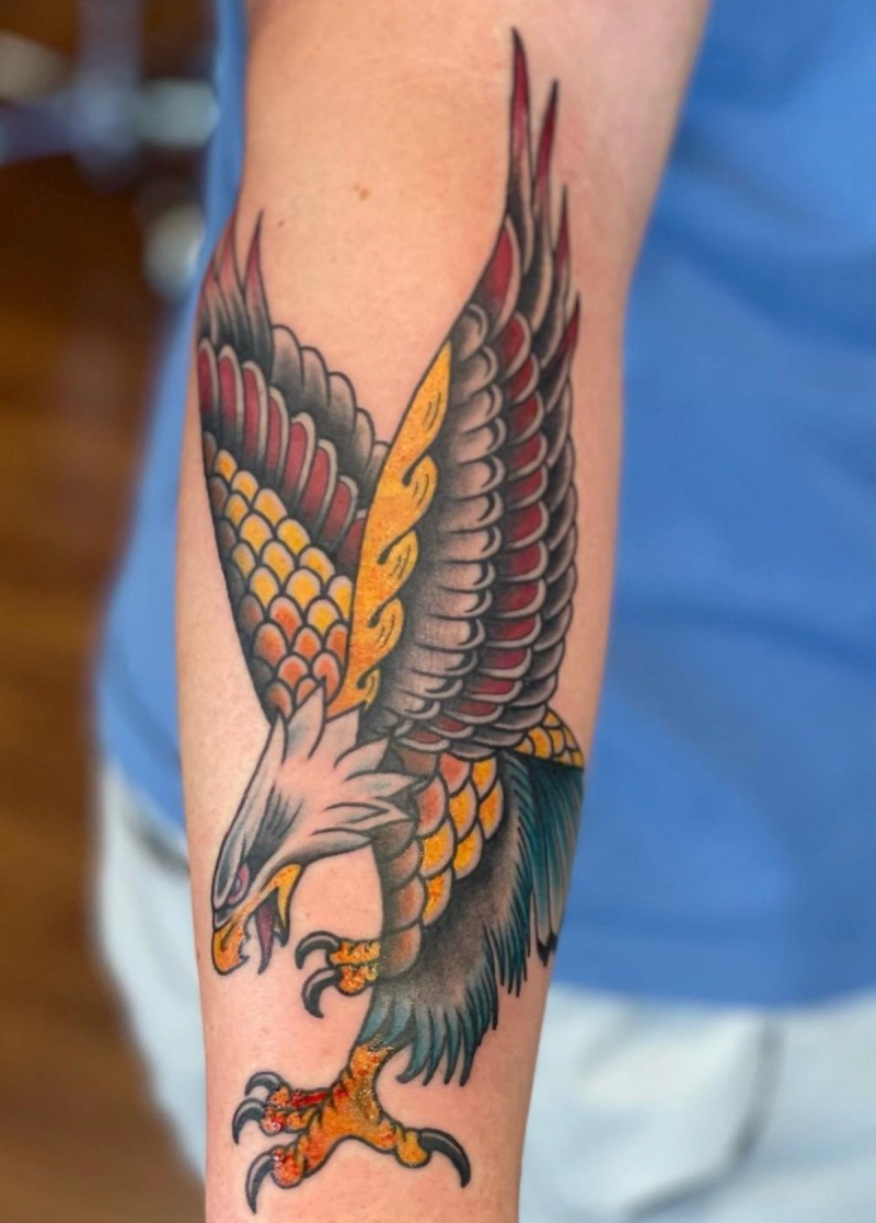 Colorful traditional eagle tattoo on forearm