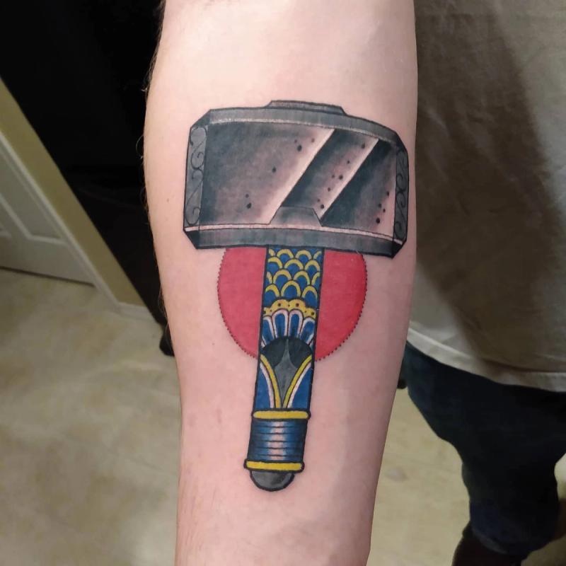colorful hammer tattoo on forearm