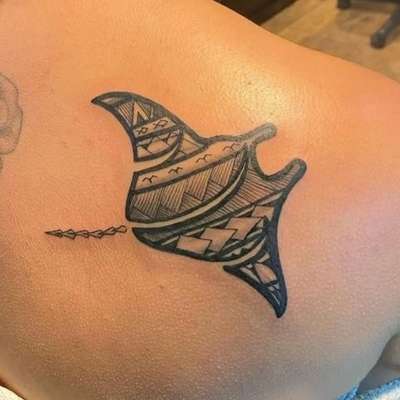 Black tribal manta ray tattoo on shoulder