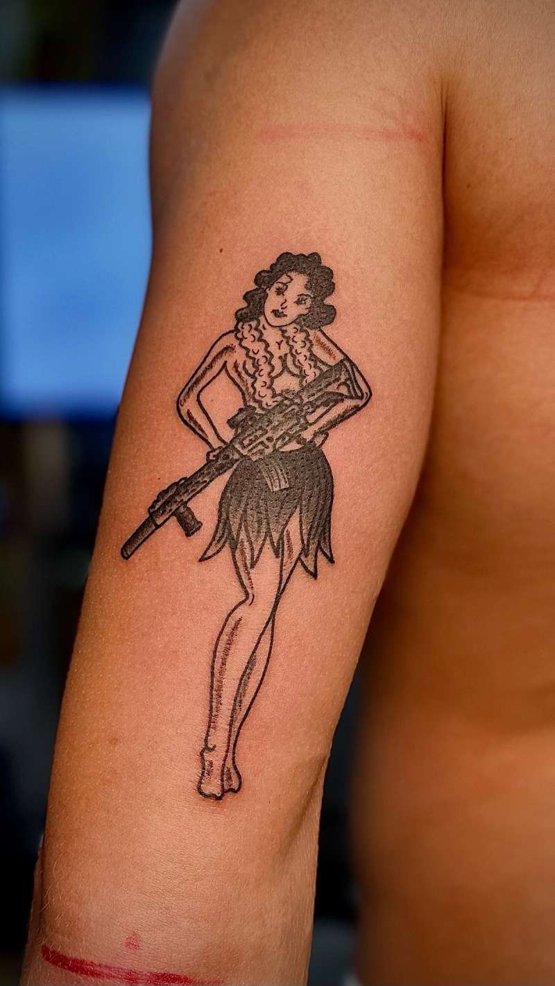 blackwork pin-up girl tattoo on upper arm