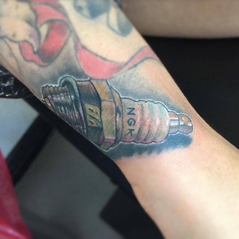 illustrative spark plug tattoo on forearm