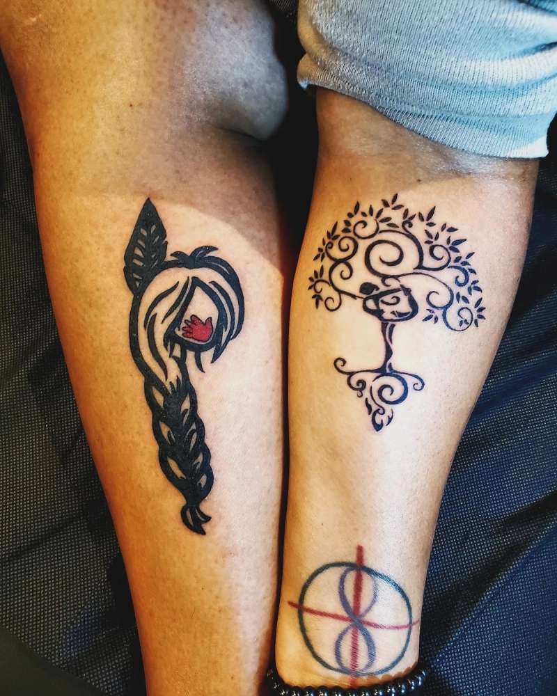 Color illustrative tattoos of abstract tree and braided hair on calf.