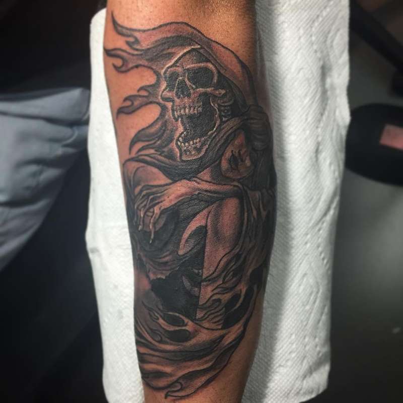 Black and grey grim reaper tattoo on forearm