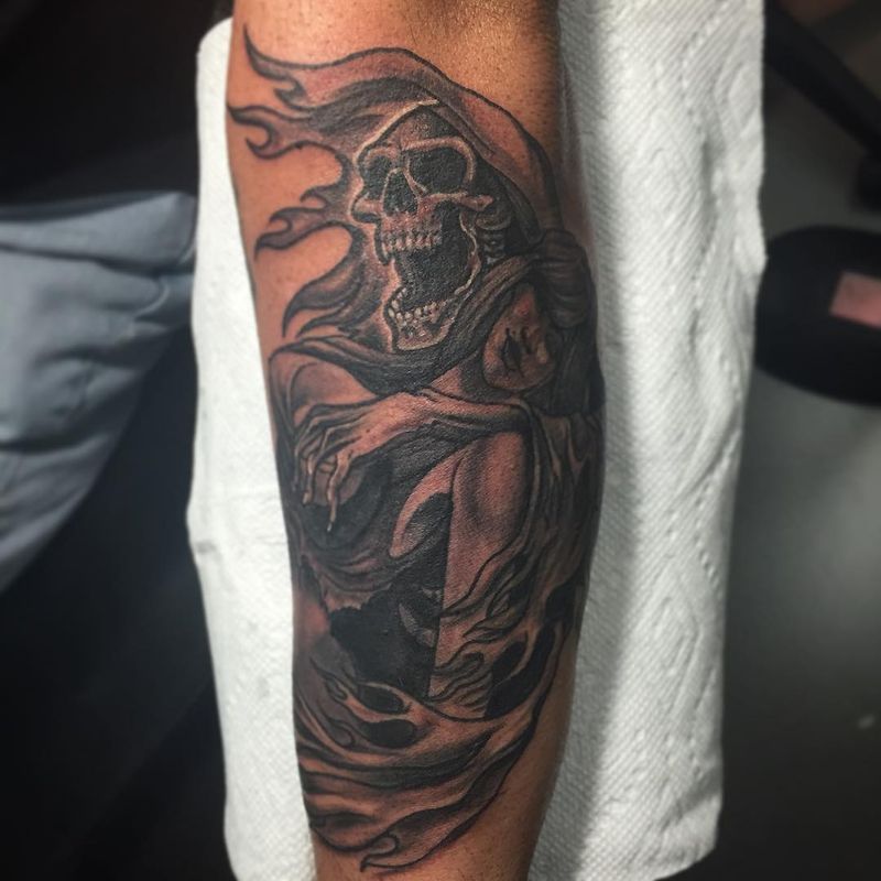 Black and grey grim reaper tattoo on forearm
