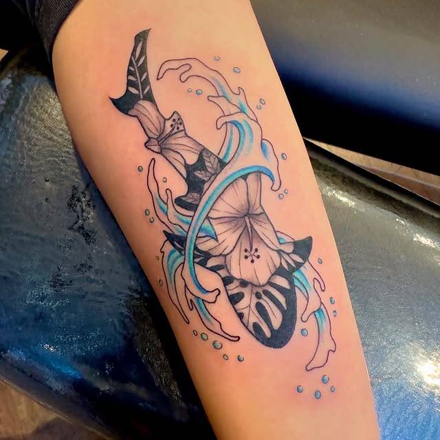 Colorful illustrative sword and flower tattoo on forearm