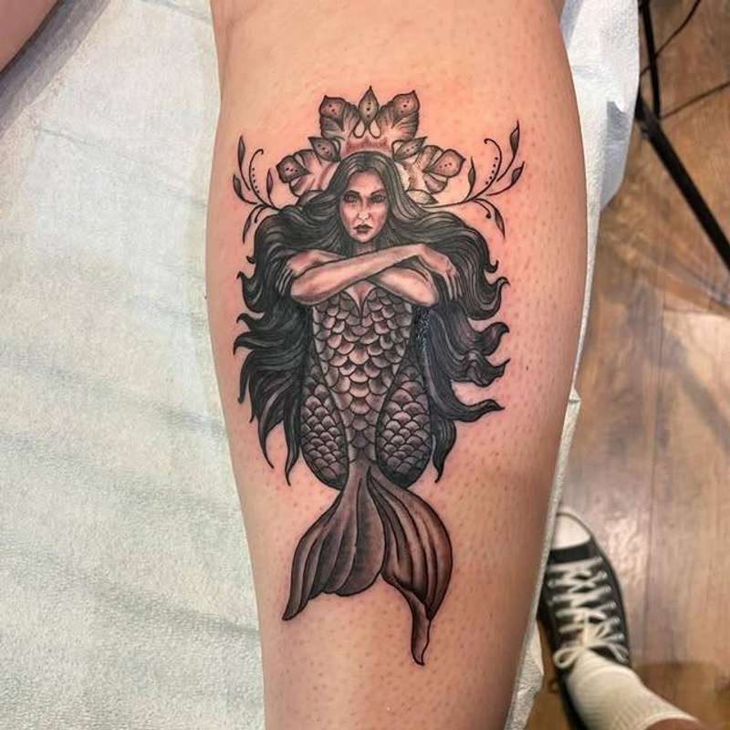 Black and grey illustrative mermaid tattoo on calf