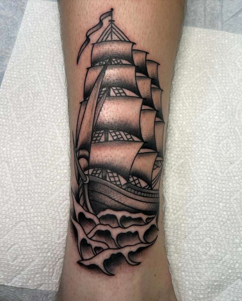 Black and grey traditional sailing ship tattoo on calf
