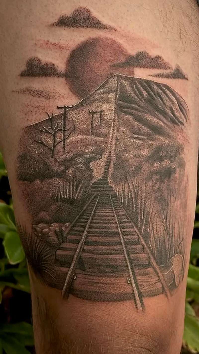 Black and grey realistic landscape tattoo on thigh