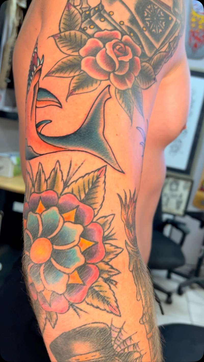 Colorful shark and rose tattoo on upper arm