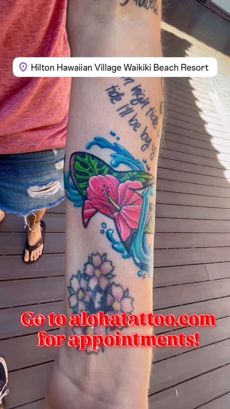 colorful floral and butterfly tattoo on forearm with text