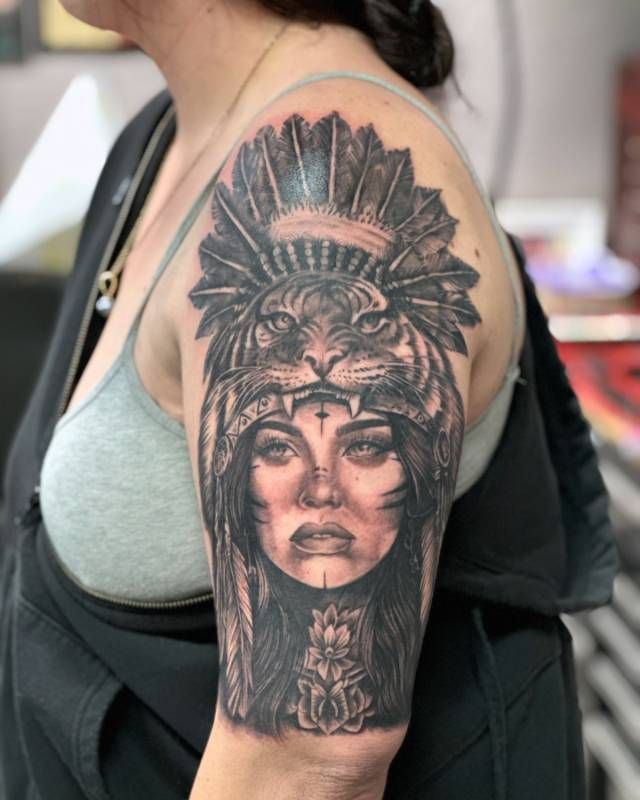 Black and grey realistic woman with tiger headdress tattoo on upper arm