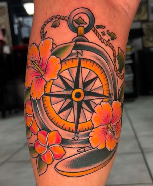 Colorful neotraditional compass and hibiscus tattoo on upper arm