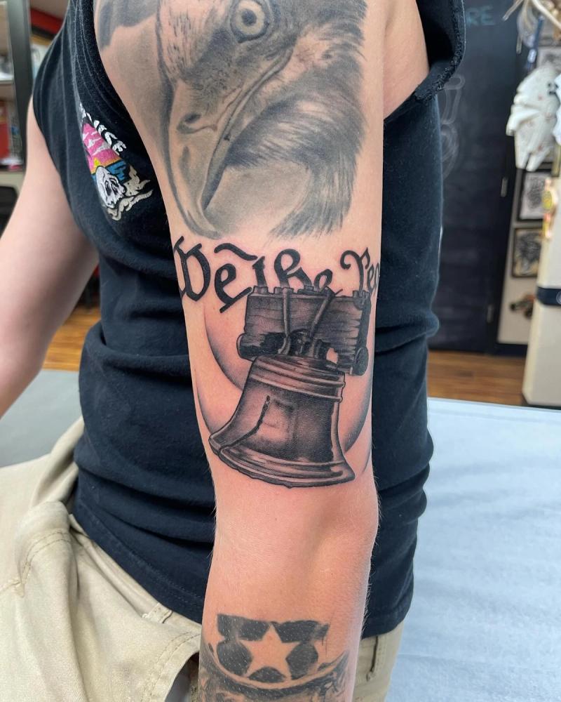 liberty bell and eagle tattoo on upper arm