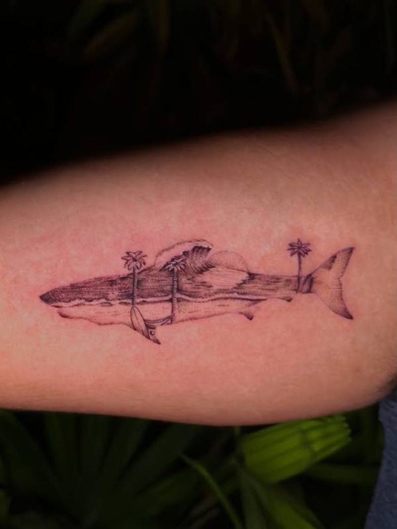 Black and grey illustrative shark with palm trees tattoo on forearm