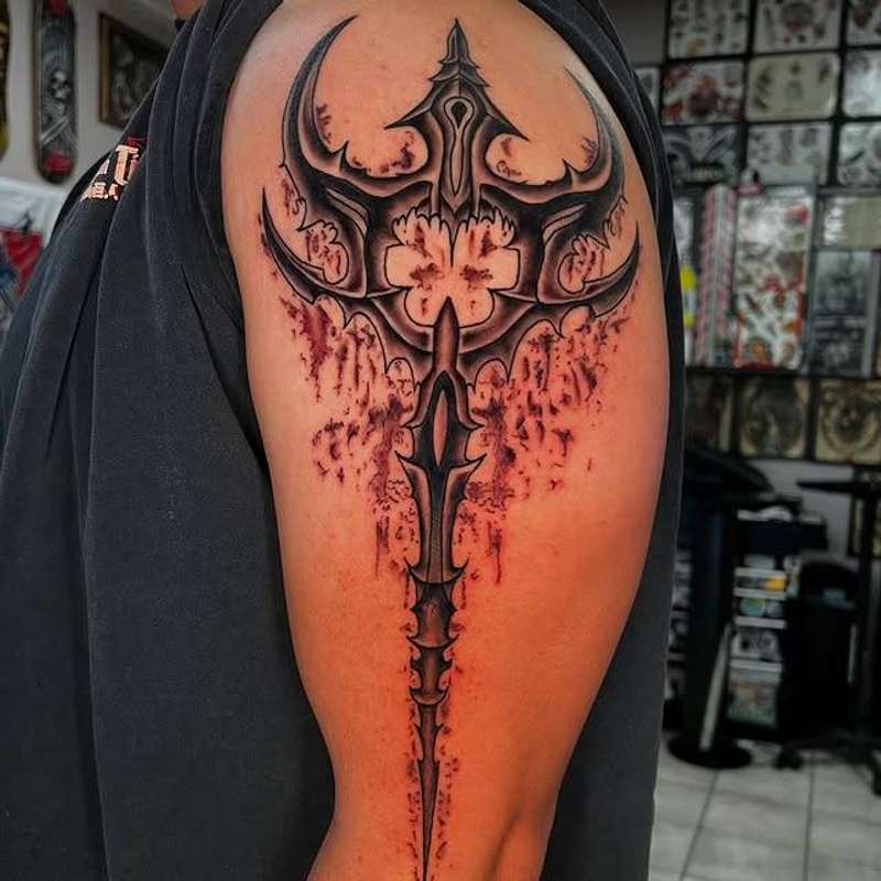 Black and grey tribal design on upper arm