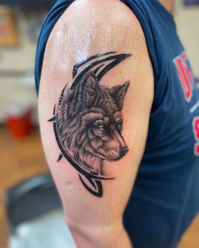 black and grey wolf tattoo on upper arm