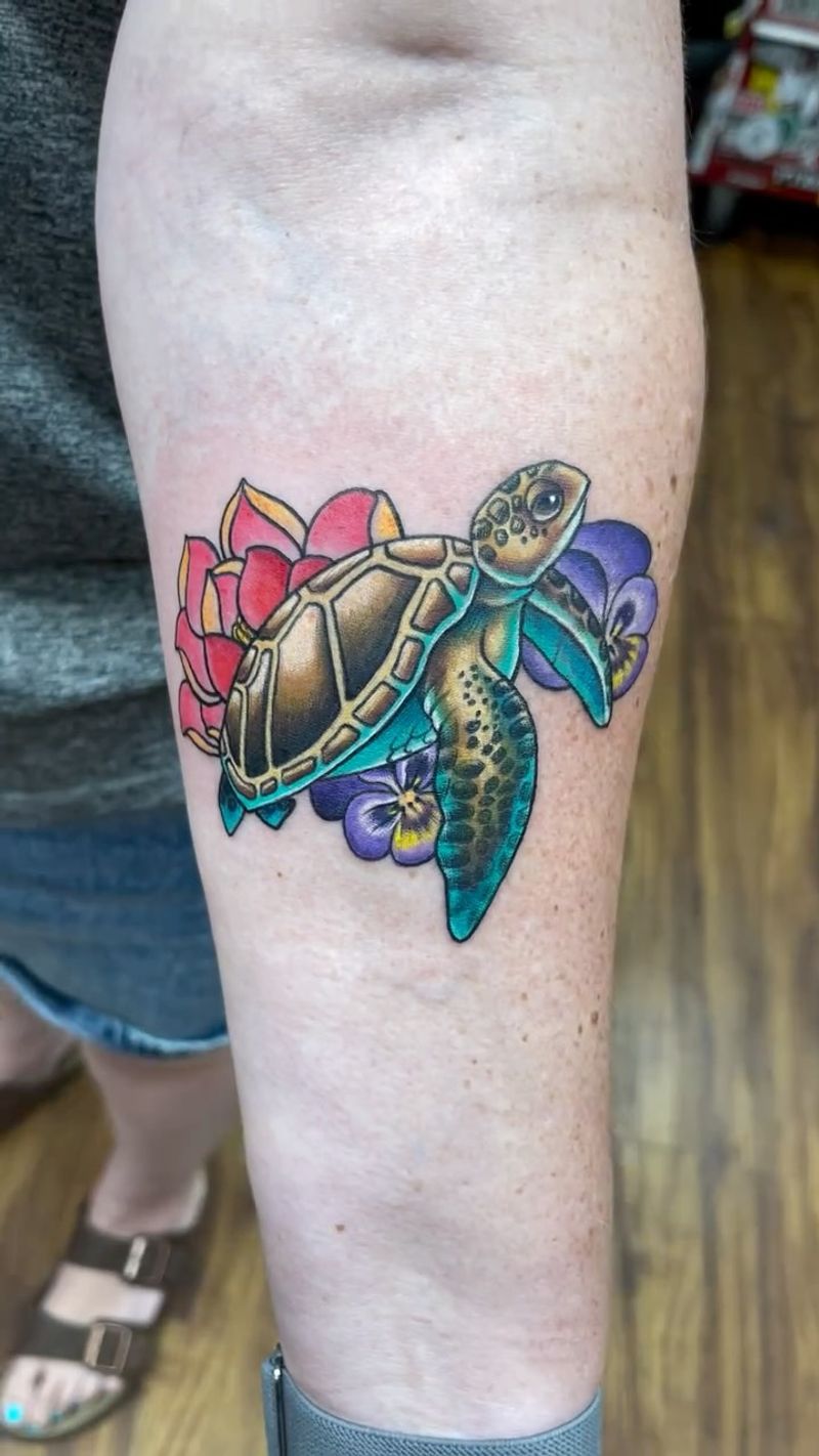 colorful turtle and flowers tattoo on the forearm