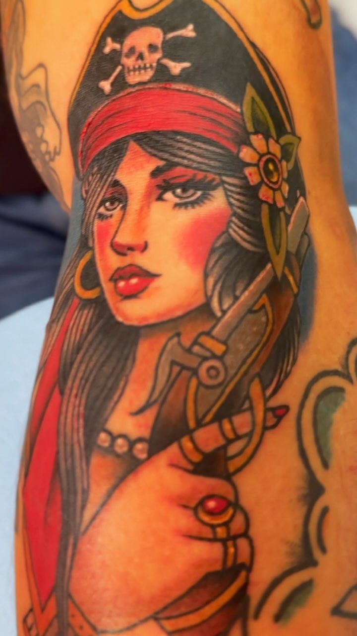 Colorful Neo Traditional tattoo of a pirate woman on upper arm