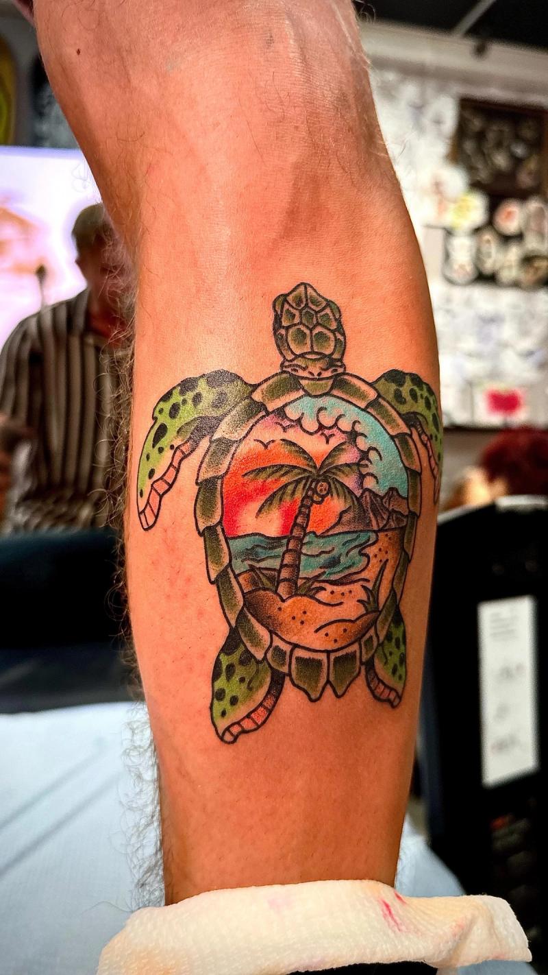 sea turtle tattoo with sunset on calf