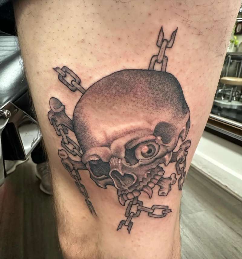 Black and grey skull and chains tattoo on thigh