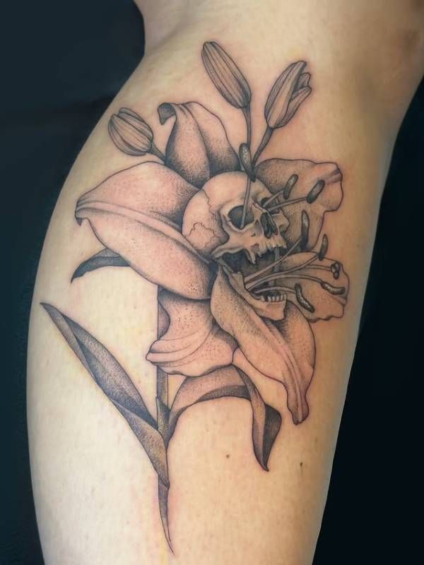 Black and grey skull and lily tattoo on forearm